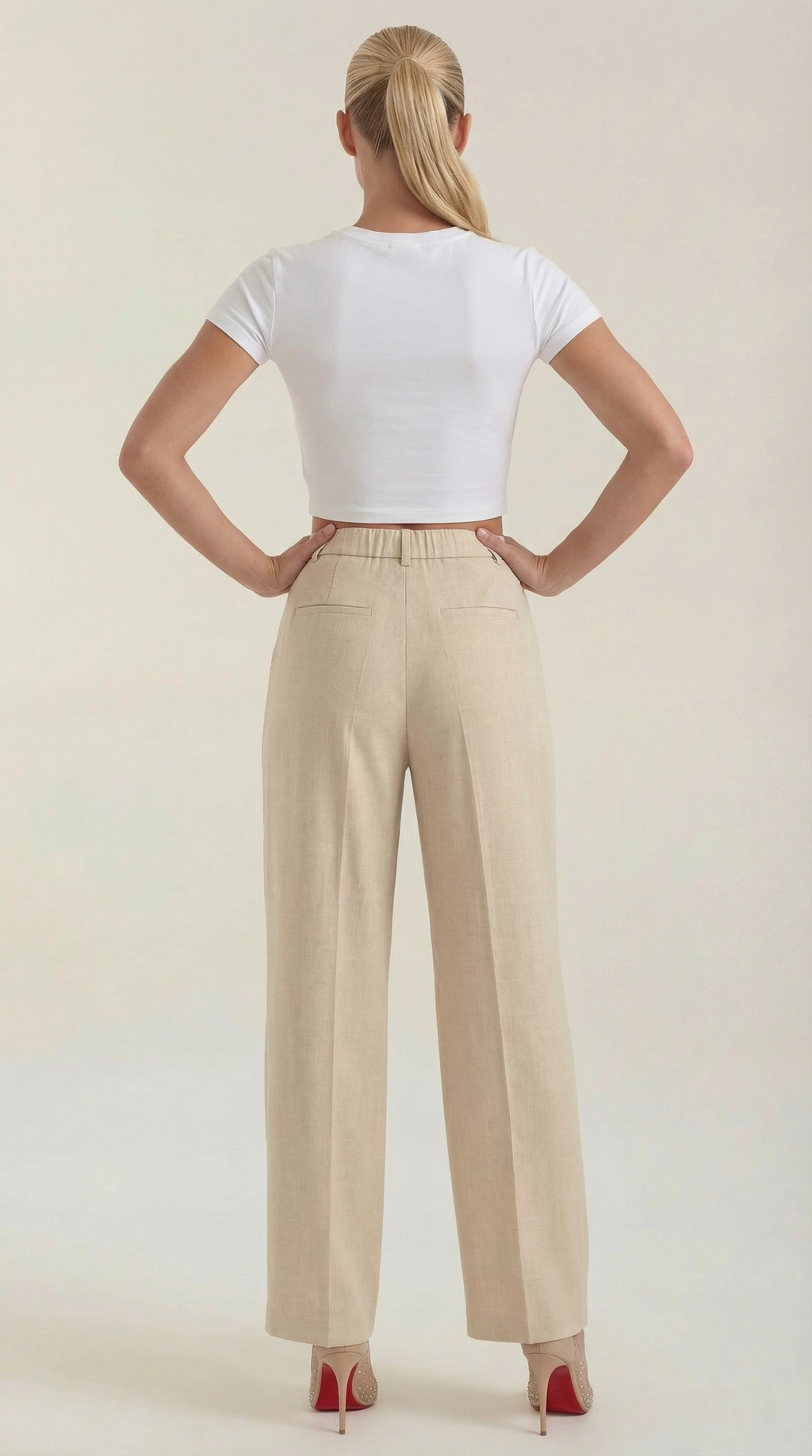 Women’s pleated high-rise wide-leg pants, light beige shown from the back