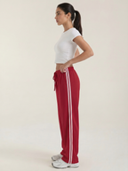 Red wide-leg track pants with white side stripes and ruched drawstring waist