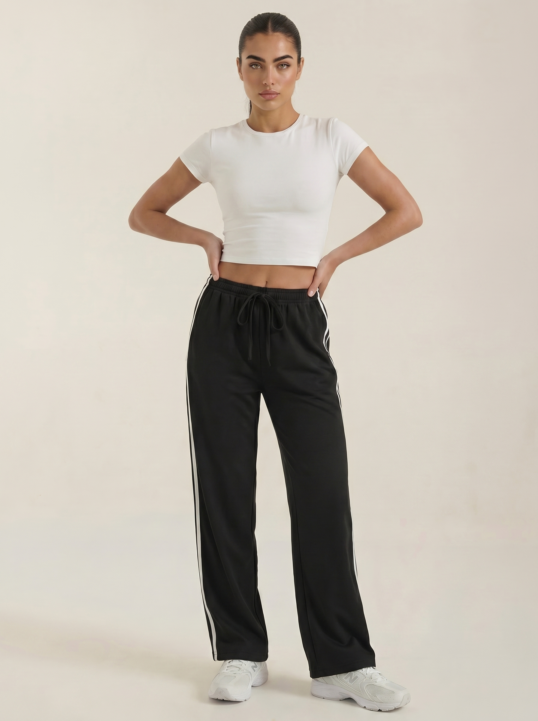 Black wide-leg track pants with white side stripes and elastic drawstring waist